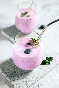 Blueberry smoothie in a glass on the table. ideal for vegetarian breakfast, diets and detox