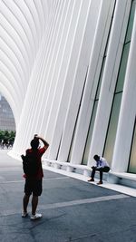 Full length rear view of couple walking in city