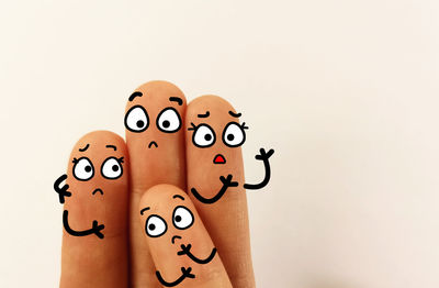 Close-up of hand with toy against white background