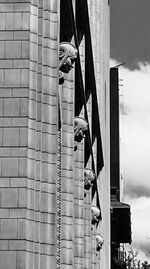 Low angle view of man hanging on metal structure