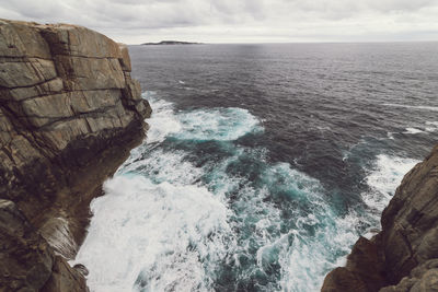 Scenic view of rocks in sea against sky