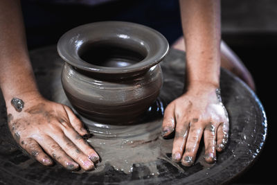 Cropped hands of man making pot in workshop