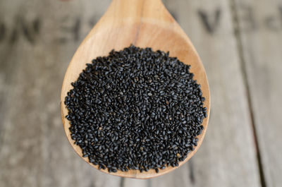 Close-up of black chia seeds in wooden spoon