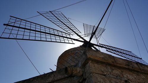 Low angle view of traditional windmill against clear blue sky