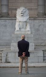 Rear view of man standing against building