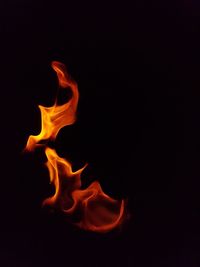 Close-up of illuminated fire against black background