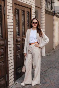 Young woman in white pantsuit and white t-shirt in city location