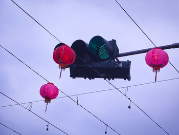 Low angle view of lanterns hanging against sky