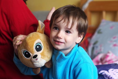 Portrait of cute boy at home with a plush toy