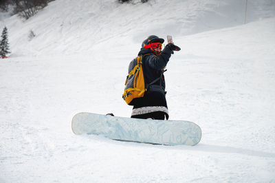 Snowboarder sits on a mountain and takes pictures. winter landscape in the french alps. beautiful