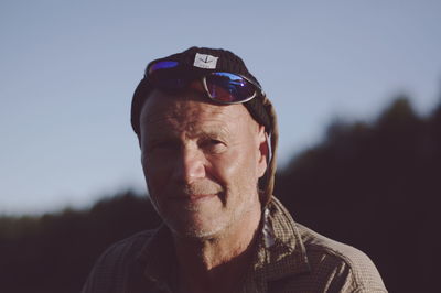 Close-up portrait of young man wearing sunglasses against sky