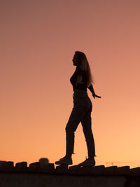 Silhouette of young woman standing against clear sky