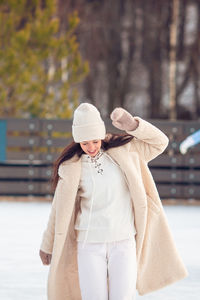 Full length of woman wearing hat standing in snow