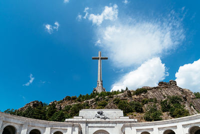 Low angle view of historical building and cross against sky