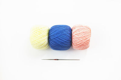 High angle view of colorful woolen balls on white background