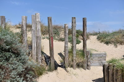 Wooden posts on field against sky