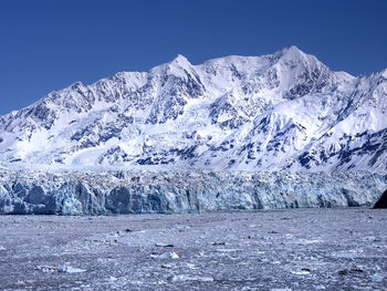 Scenic view of frozen river by snowcapped mountain