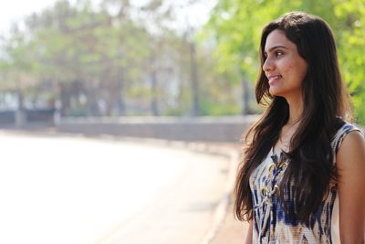 Portrait of smiling young woman standing outdoors