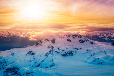 Scenic view of snowcapped mountains against sky during sunset