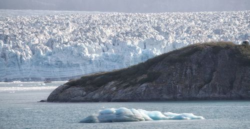 Scenic view of frozen sea by mountain against sky