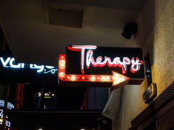 Low angle view of illuminated information sign at restaurant