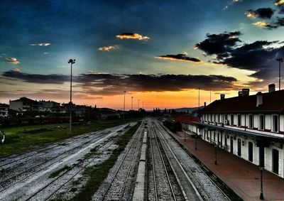 Railroad tracks against sky during sunset