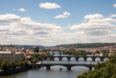 Bridge over river in city against sky