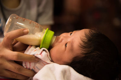 Cropped hand of person feeding baby