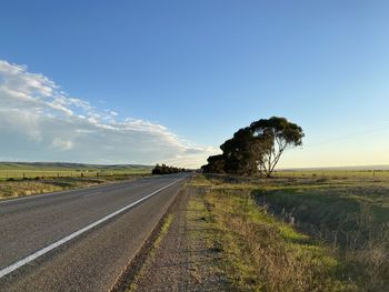 Road amidst field against sky