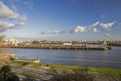 Scenic view of river against sky in city