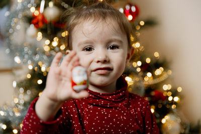 Baby girl shows a gift from a wall advent calendar.