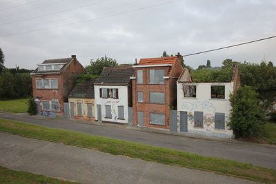 Houses by street against sky in city