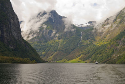 Scenic view of mountains and sea against cloudy sky