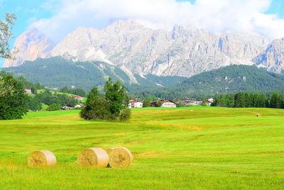 Hay bales on field against sky