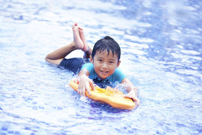 Portrait of boy leaning swimming in pool