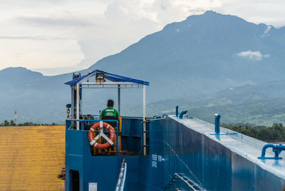 Man standing by sea against mountains