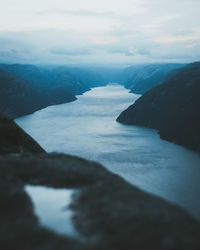 Fjord amidst rock formations against sky during winter