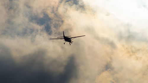 Low angle view of silhouette airplane against sky during sunset