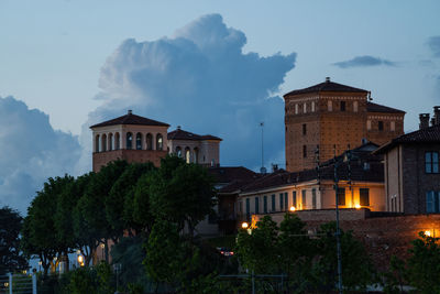 Street amidst buildings against sky at dusk