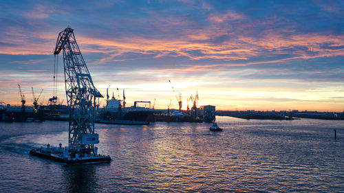 Scenic view of commercial dock against sky during sunset