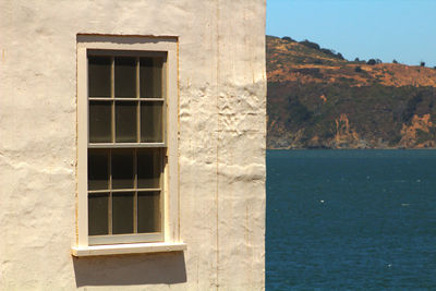 Exterior of building by sea against sky