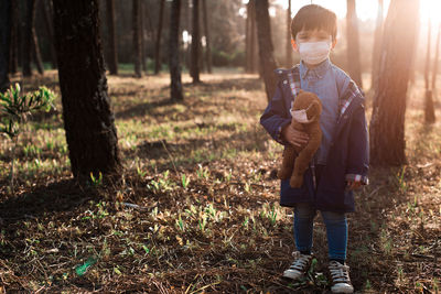 Full length of man standing on field in forest