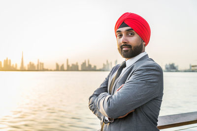 Portrait of businessman wearing turban standing by river