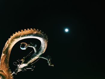 Close-up of illuminated lamp over black background