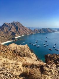 Scenic view of sea and mountains against clear blue sky