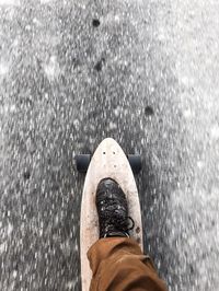 Low section of man skateboarding on road