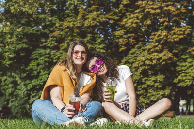 Portrait of a smiling young woman drinking drink