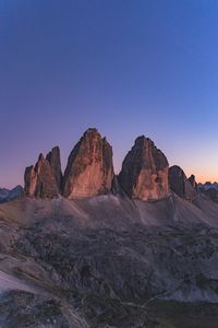 Rock formations on landscape against clear blue sky