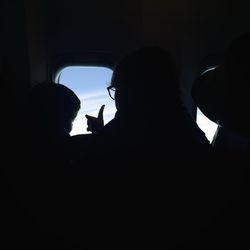 Low angle view of silhouette people on window
