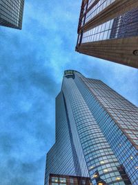 Low angle view of modern building against cloudy sky